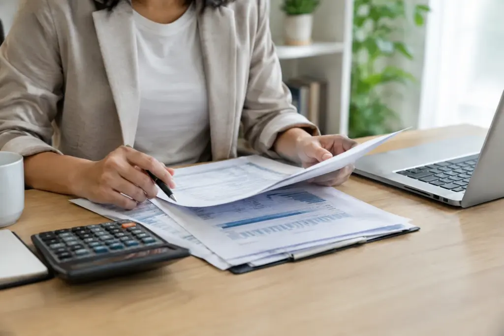 Documents de financement professionnel et calculatrice disposés sur un bureau.